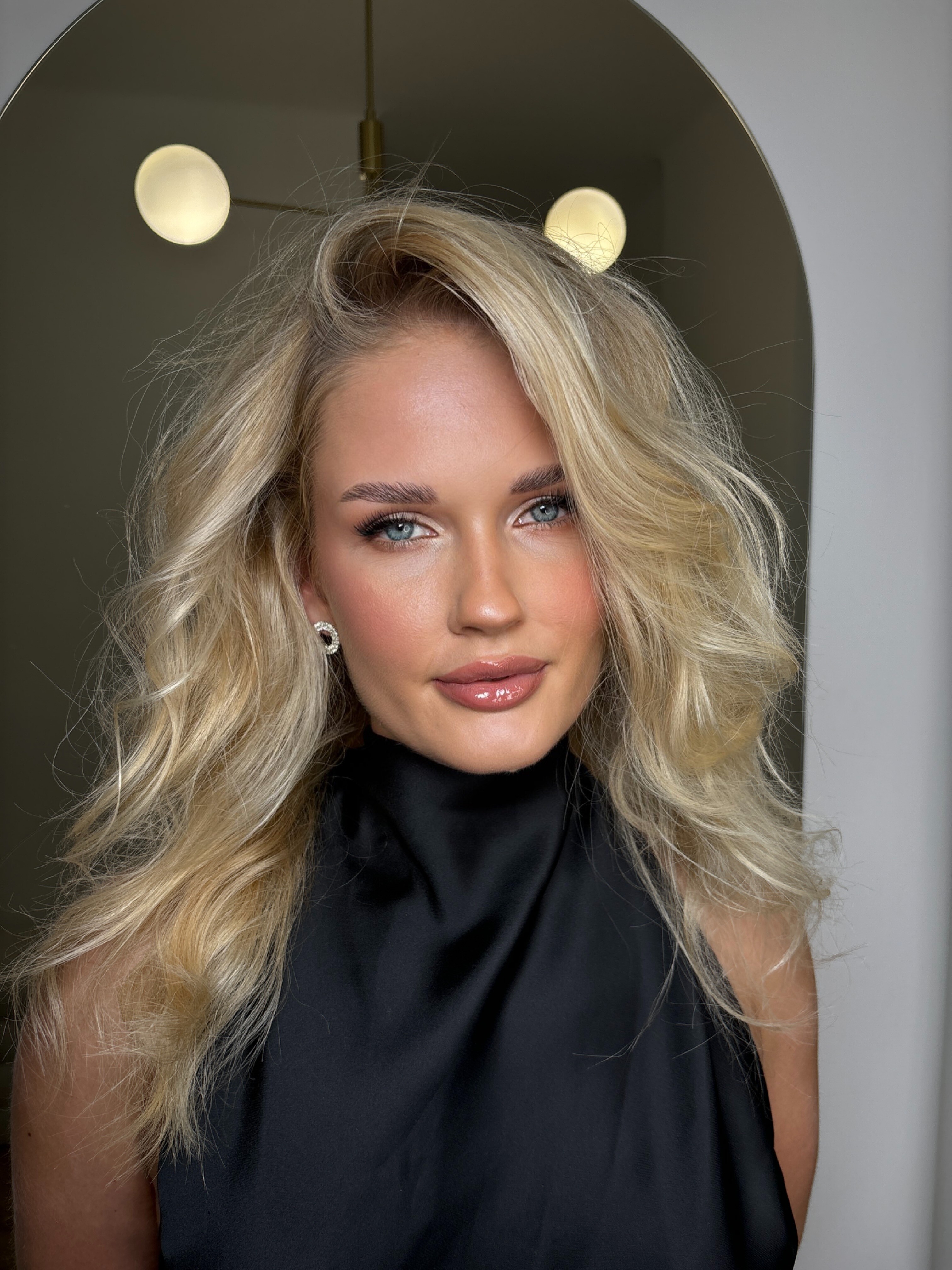 A woman poses, showing her makeup.